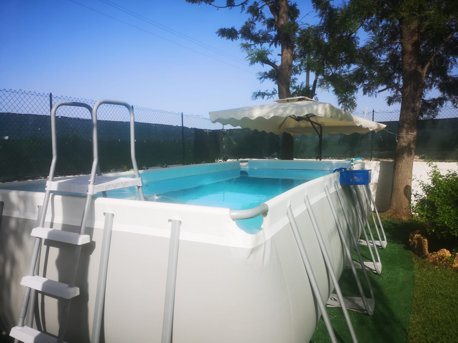 Dettaglio della piscina fuori terra con ombrellone